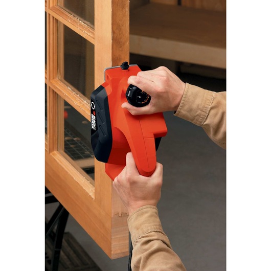 Planer being used to shave the door of cupboard.