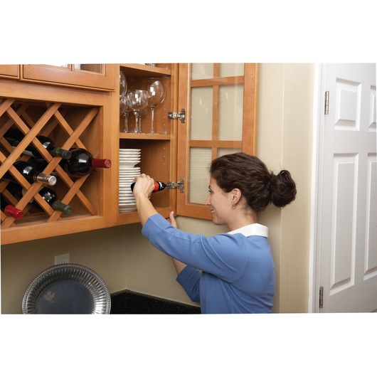 Cordless screwdriver being used by a person to drive screws.