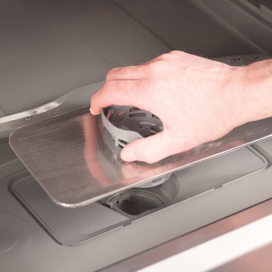 Person unblocking water drain system of 6 Place Setting Compact Countertop Dishwasher.