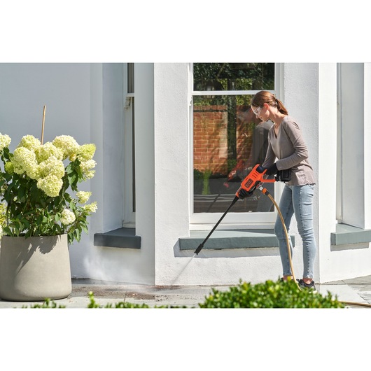 Cordless Power Cleaner Kit being used for cleaning mud outside house.