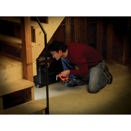 20 volt MAX lithium ion 4 tool combo kit: drill driver, circular saw, reciprocating saw and work light being used by a person to view under stairs. 