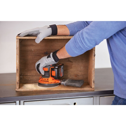 20 volt MAX Cordless Random Orbital Sander being used on a wooden structure.