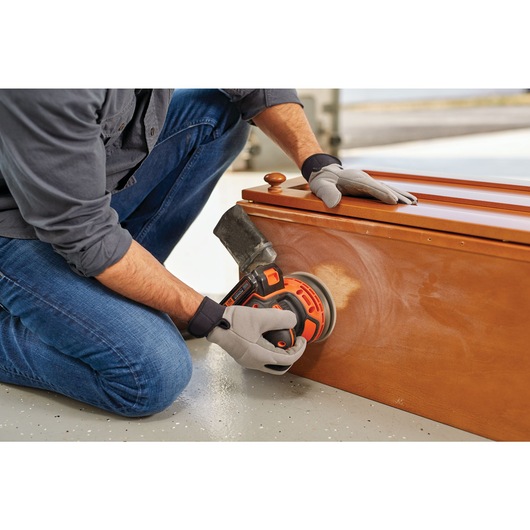 Cordless Random Orbital Sander being used to sand wooden structure.