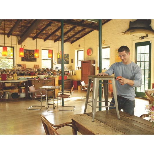 A person fixing stool using Lithium rechargeable screwdriver.