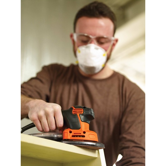 MOUSE detail sander being used by a person to sand wood.