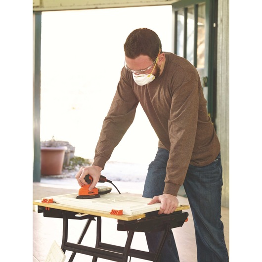MOUSE Detail Sander being used by person to sand wood.