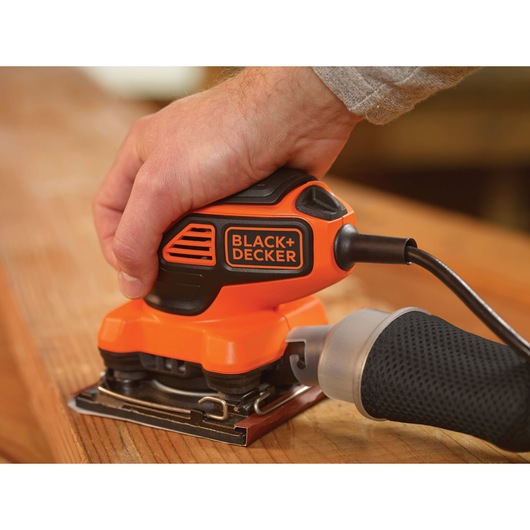 One quarter Sheet Orbital Sander with Paddle Switch Actuation being used to prepare and smooth wooden surface.