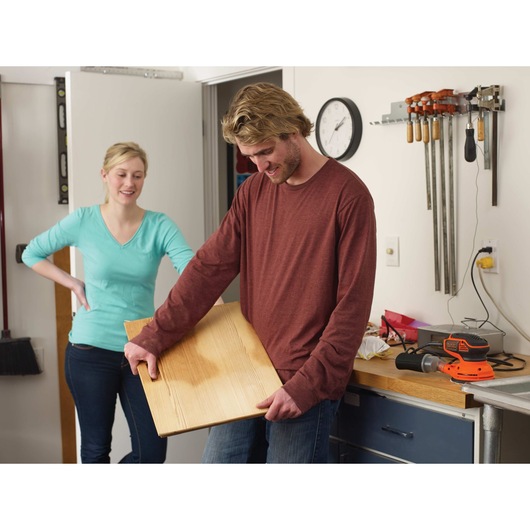 5 inch random orbital sander being held by a person.