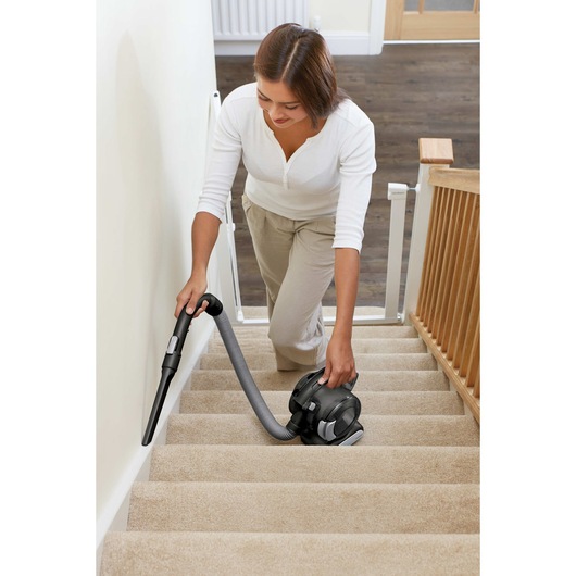 Dust buster Flex Cordless Hand Vacuum with Floor Head plus Pet Hair Brush being used by person on staircase side.