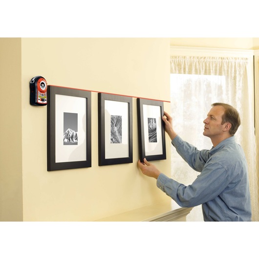Bulls Eye Auto Leveling Laser with Angle Pro being used for leveling 3 picture frames on wall.