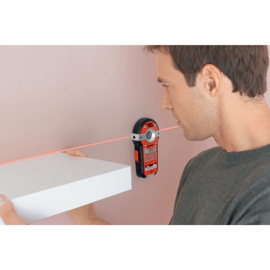 BullsEye auto leveling laser with stud sensor being used to mount a shelf.