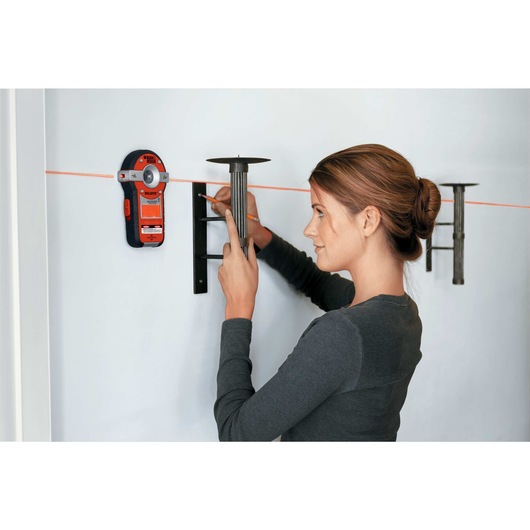 Bulls Eye Auto Leveling Laser with Stud Sensor being used to level candle stands on the wall.