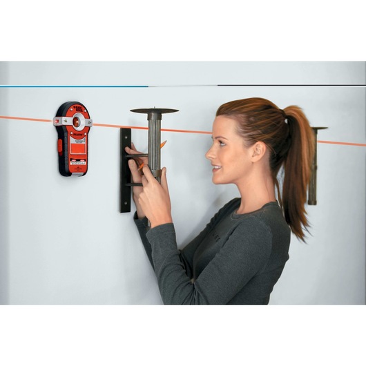 Bulls Eye Auto Leveling Laser with Stud Sensor being used to level a candle stand on a wall.