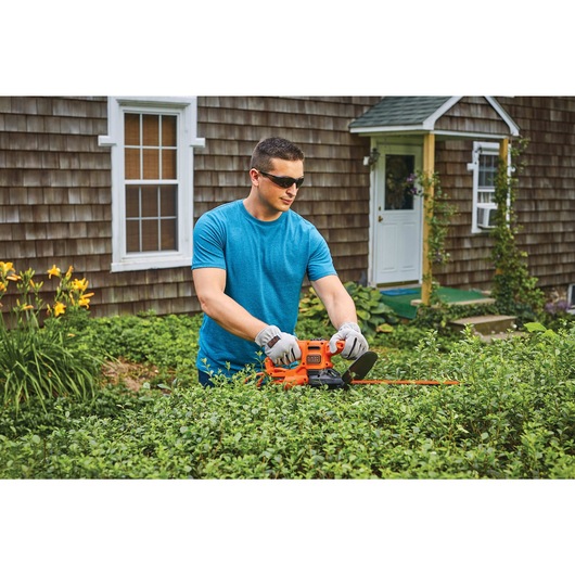 17 inch electric hedge trimmer being used to trim a hedge.