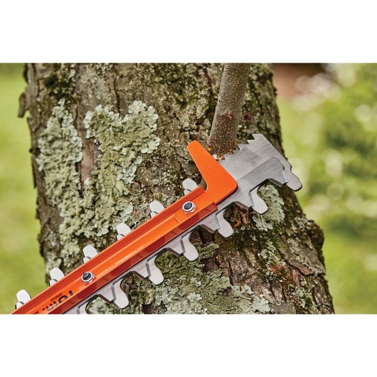 16 inch SAWBLADE electric hedge trimmer being used to prune branch.