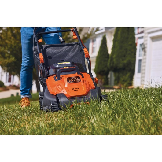 10 Amp 15 inch Electric Lawn Mower with Comfort Grip Handle being used for mowing grass.