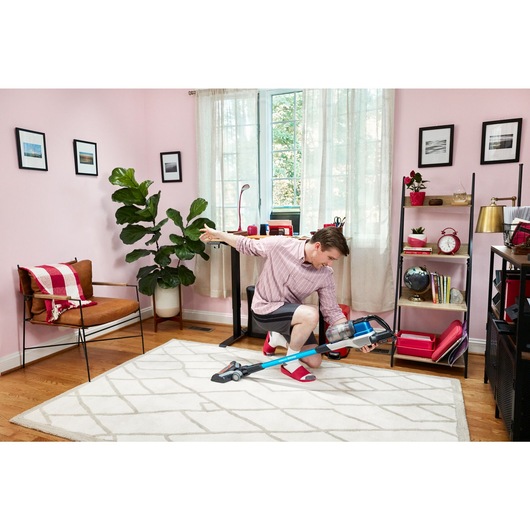 man dancing with BLACK+DECKER PowerseriesExtreme stick vacuum in home office