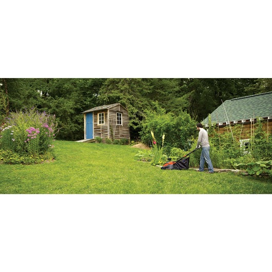 Lithium 16 inch Mower being used for mowing grass by person.
