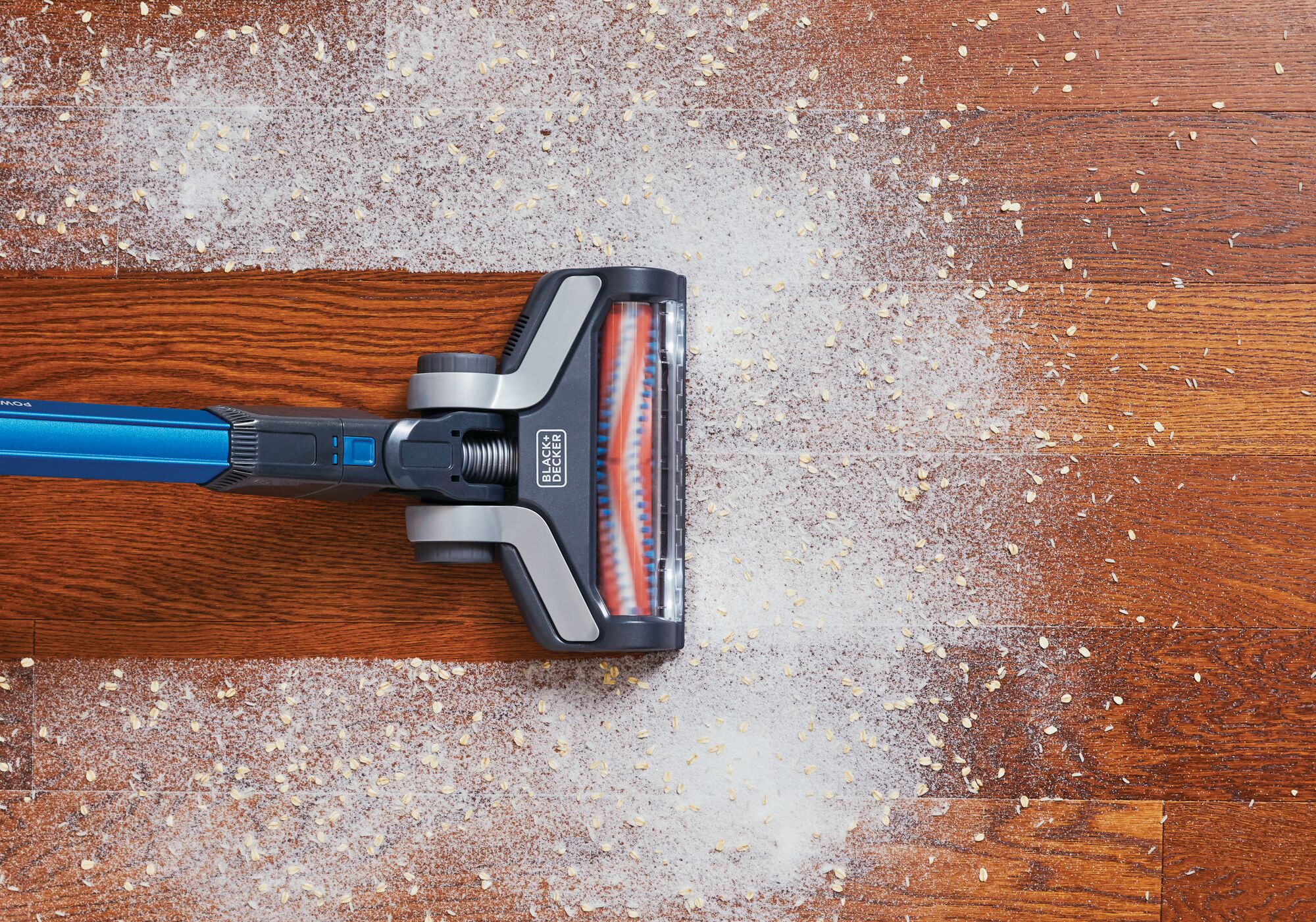 Overhead view of POWERSERIES Extreme Cordless Stick Vacuum Cleaner being used to clean mess from wooden floor.