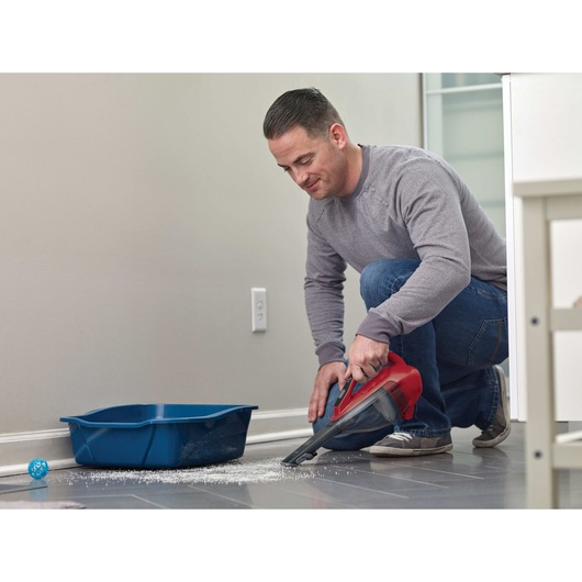 Dustbuster Advanced Clean Cordless Hand Vacuum being used to clean spilled litter on floor.