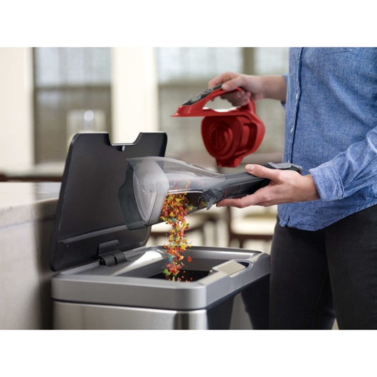 dust buster Advanced Clean Cordless Hand Vacuum being emptied into trash can.