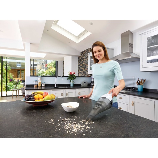 Dustbuster quickclean cordless hand vacuum being used by a person.