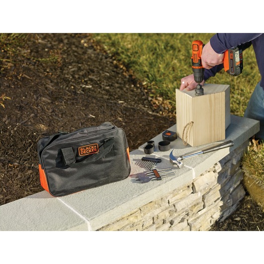 Lithium ion drill driver plus 68 piece project kit drilling wooden surface.
