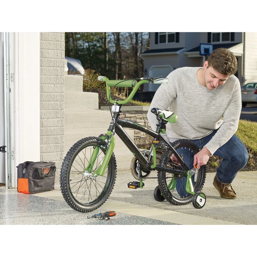 Adjustable wrench of MAX Lithium Ion Drill or Driver plus 68 Piece Project Kit being used by person to adjust nuts and bolts of bicycle.
