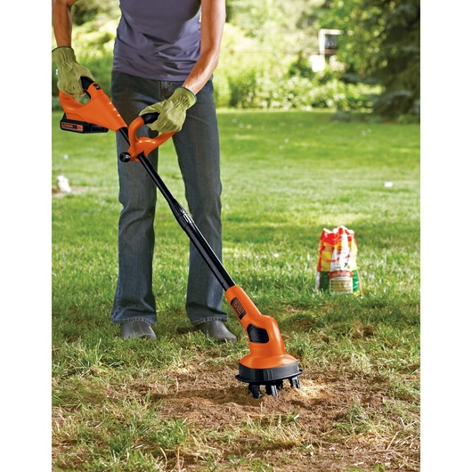 Lithium garden cultivator being used to cultivate a patch of soil.