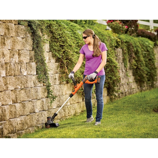40 volt MAX Lithium String Trimmer being used by a person on grass outside.