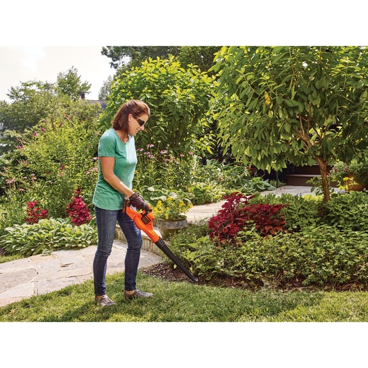 20 volt lithium power booster sweeper being used by a person.