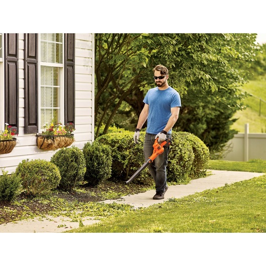 40 volt MAX sweeper being used by a person to clean sidewalk.